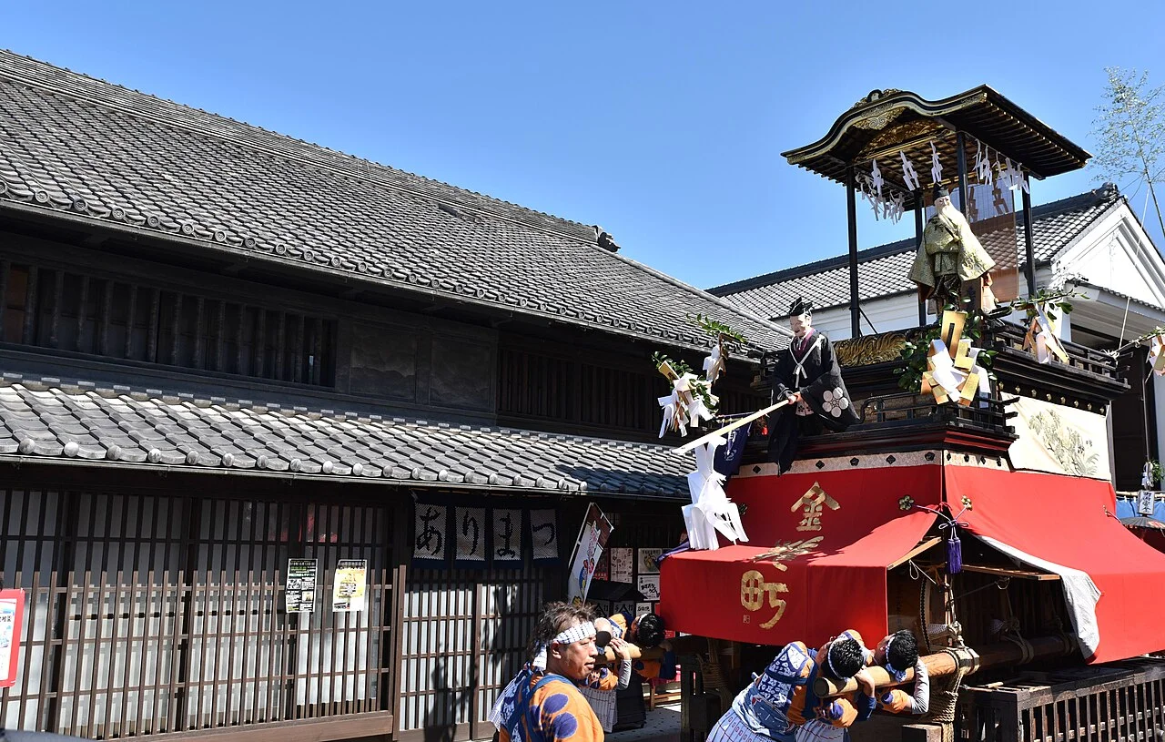 有松の秋祭りで町並みの前を進む山車と曳き手