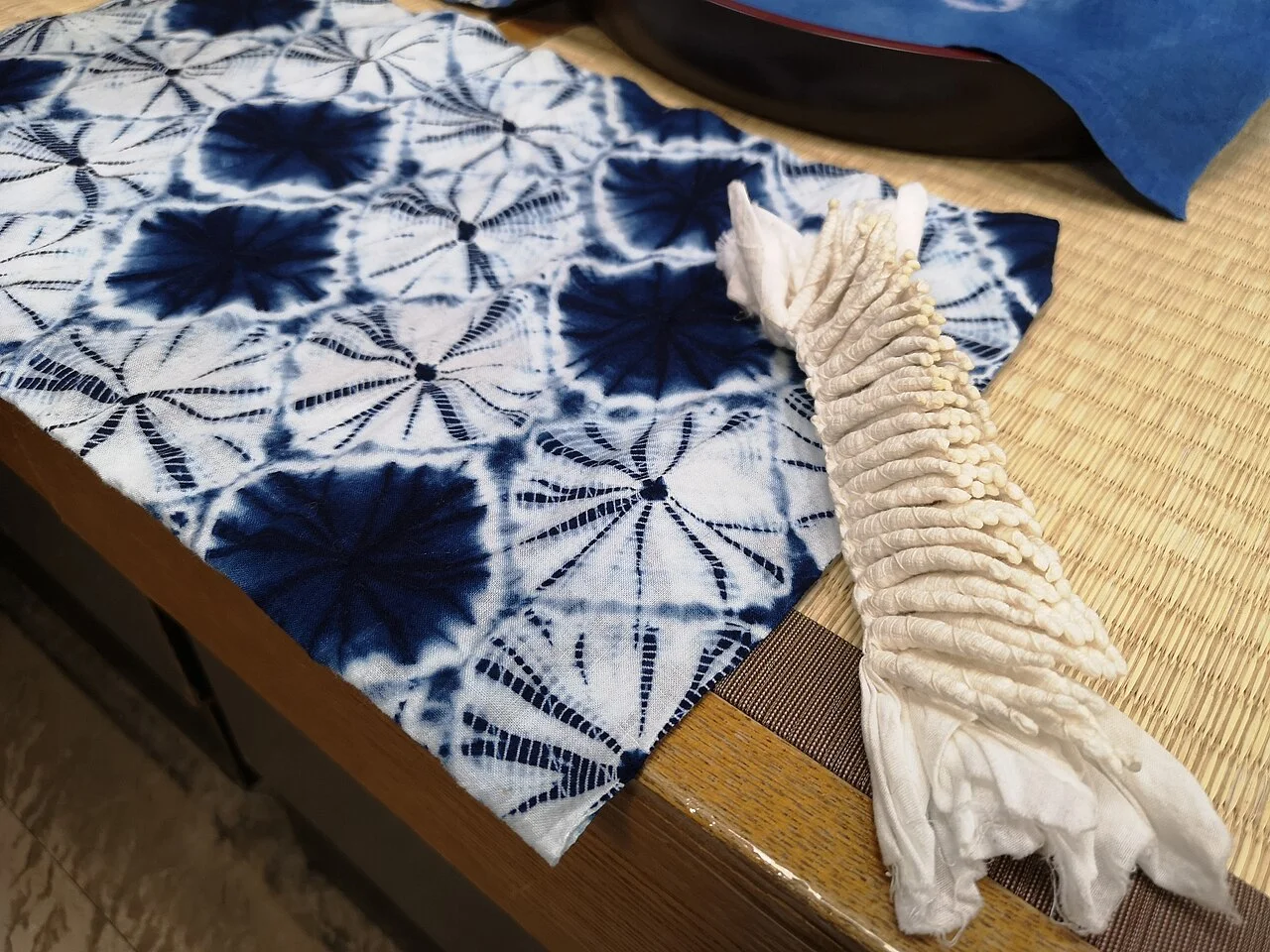 手蜘蛛絞りの糸でくくった白い布と染め上がった模様