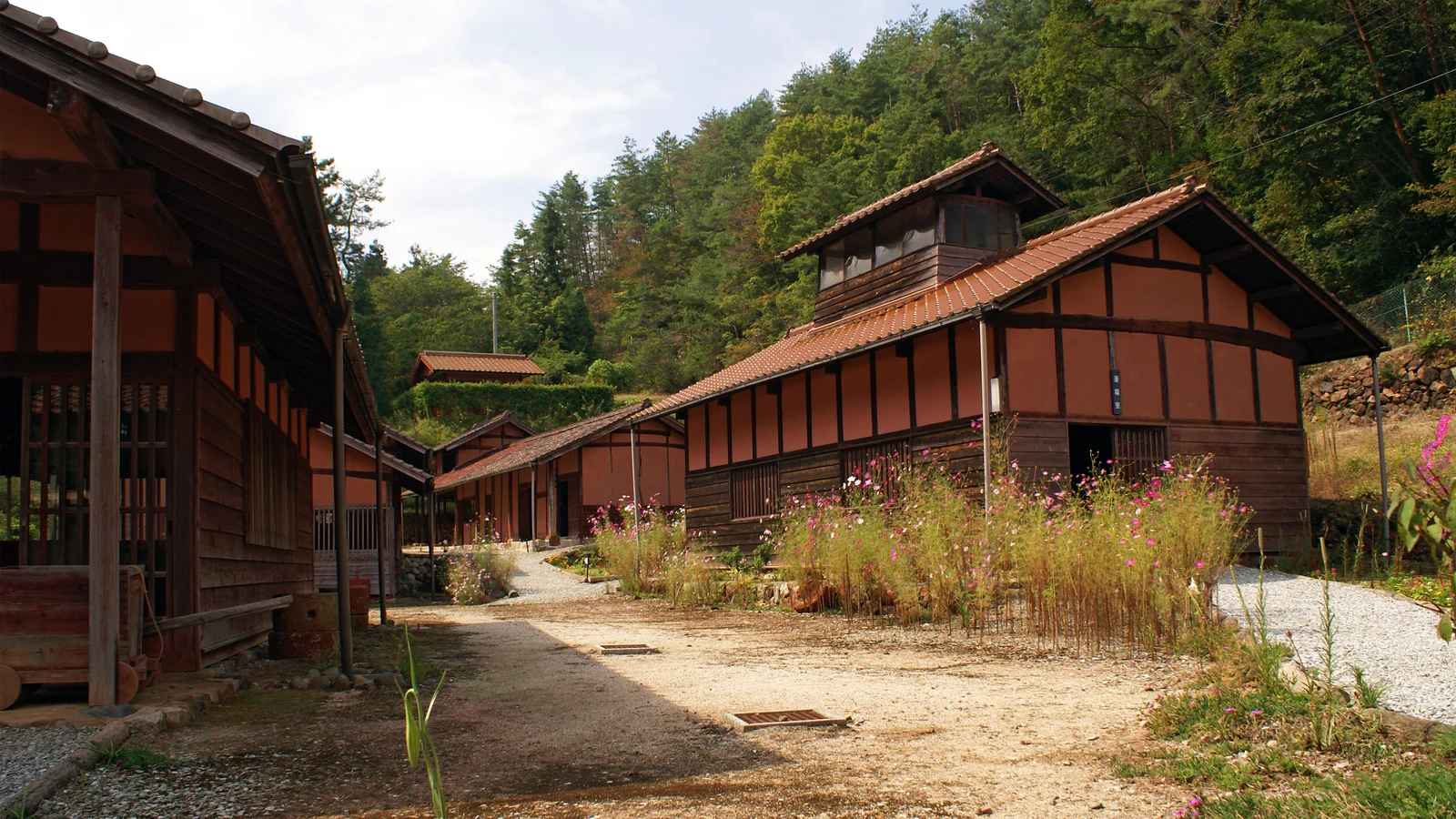 山の斜面に沿って建つベンガラ館の復元工場と建物の間の道
