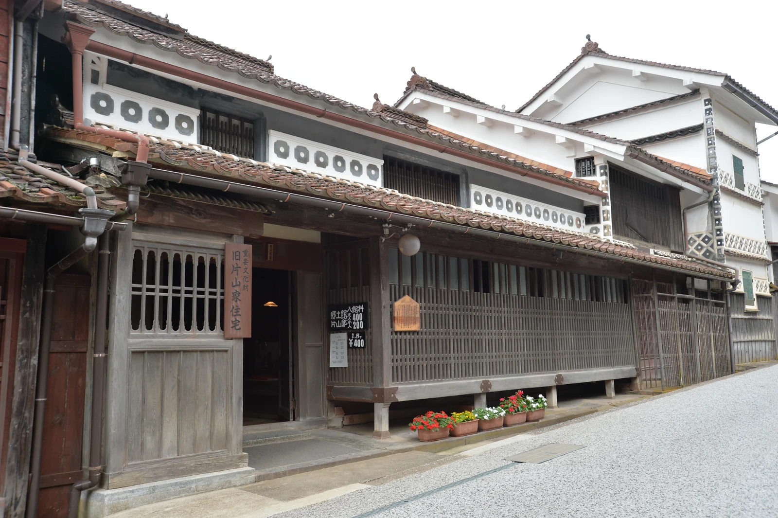格子が続く旧片山家住宅の正面と赤茶色の瓦屋根