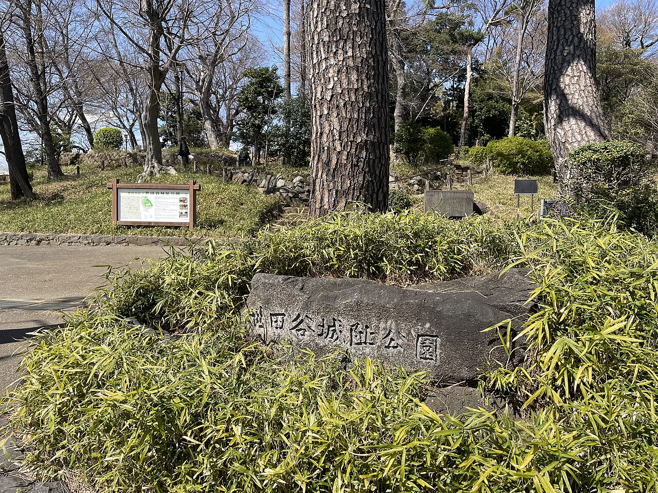 世田谷城阯公園の石標と、背後に残る起伏や木々