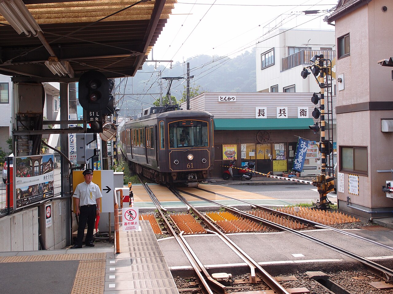 長谷駅のホーム脇を江ノ電が通り、すぐ先に街の踏切がある