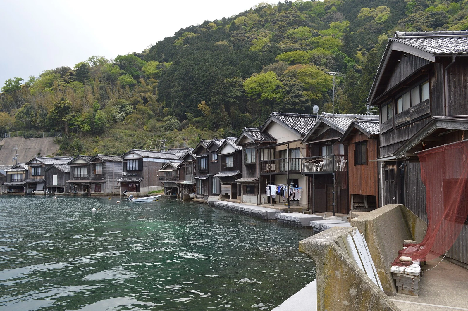 海側に洗濯物が干され、舟が係留された伊根浦