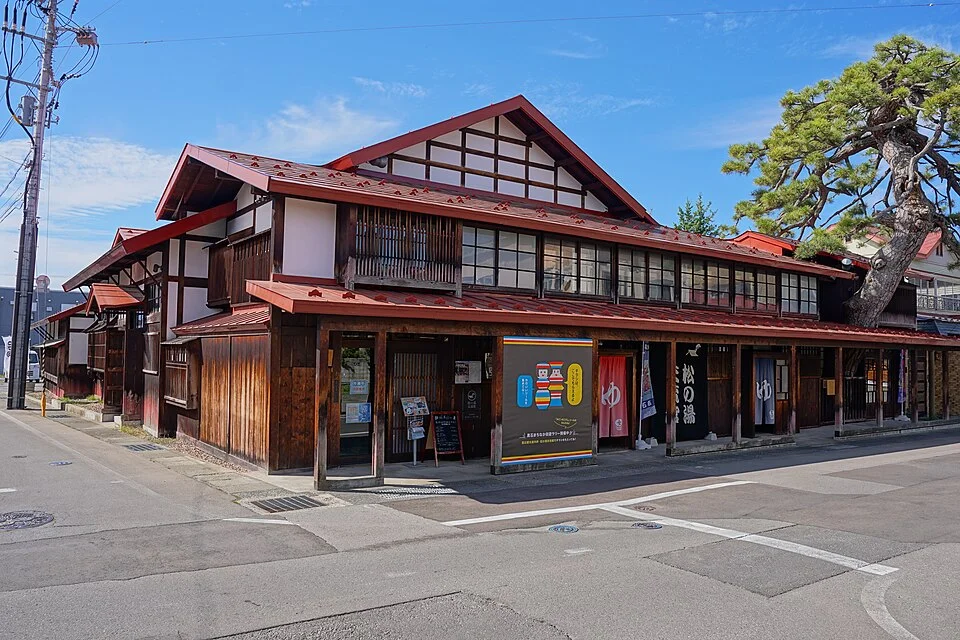 松の木を屋根から伸ばす松の湯交流館の外観