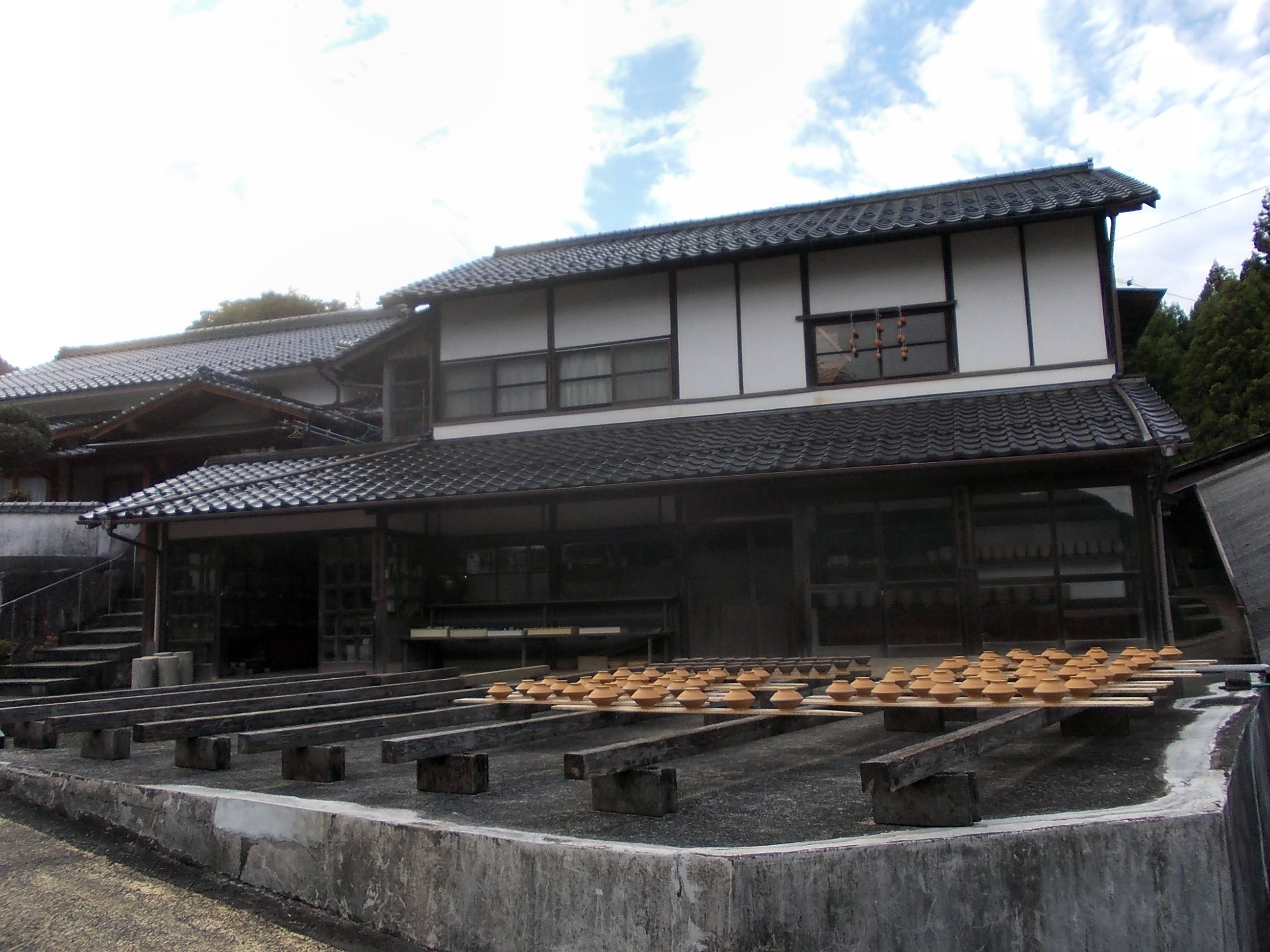 小鹿田皿山の家の前で、板の上に器を並べて乾かす様子