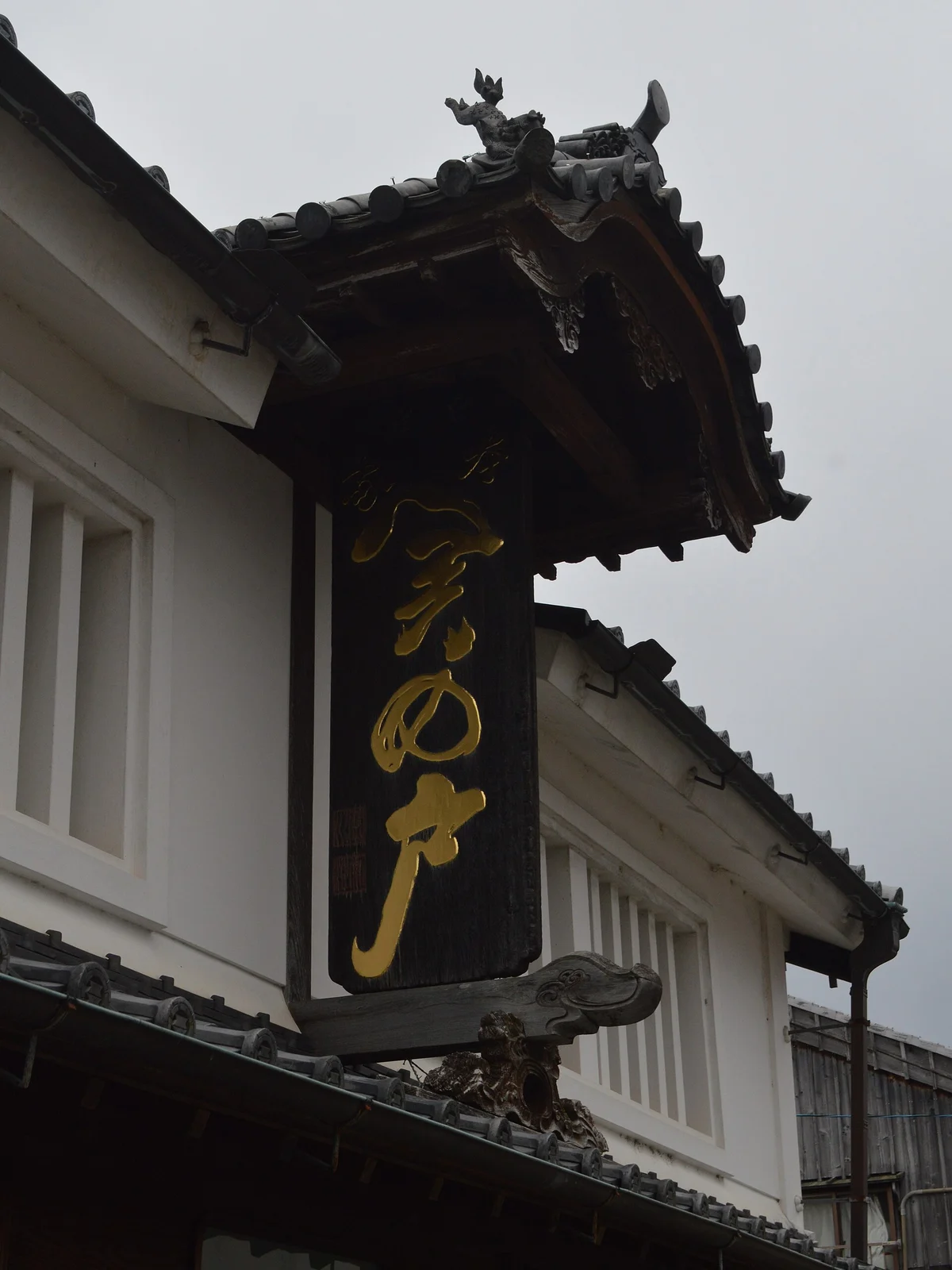小さな瓦屋根を載せた深川屋の関の戸の看板