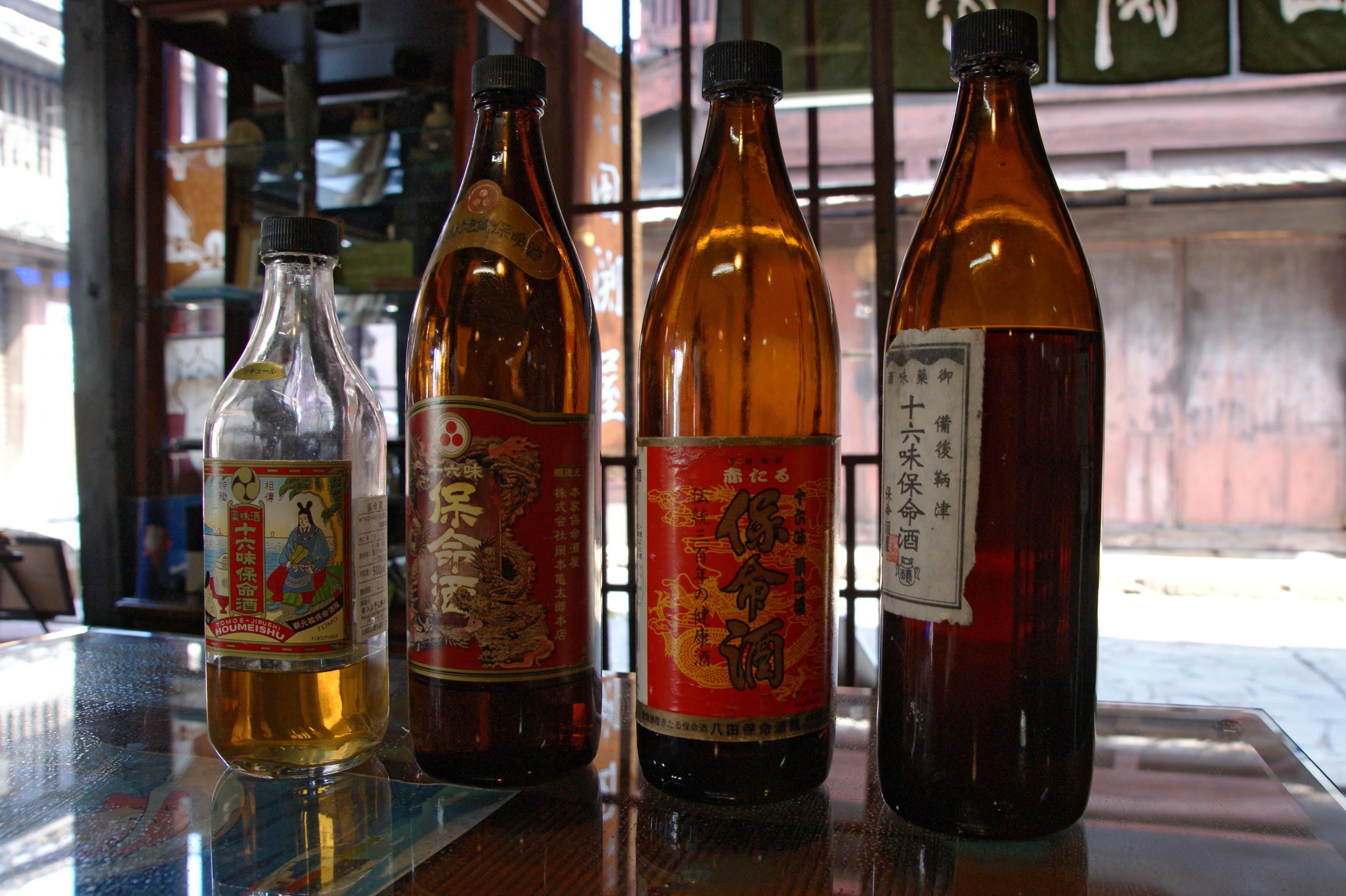 異なるラベルの保命酒の瓶が四本並ぶ