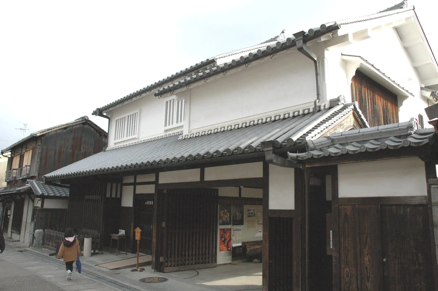 白い壁と格子を備え、入口に案内板が置かれた寺内町センター