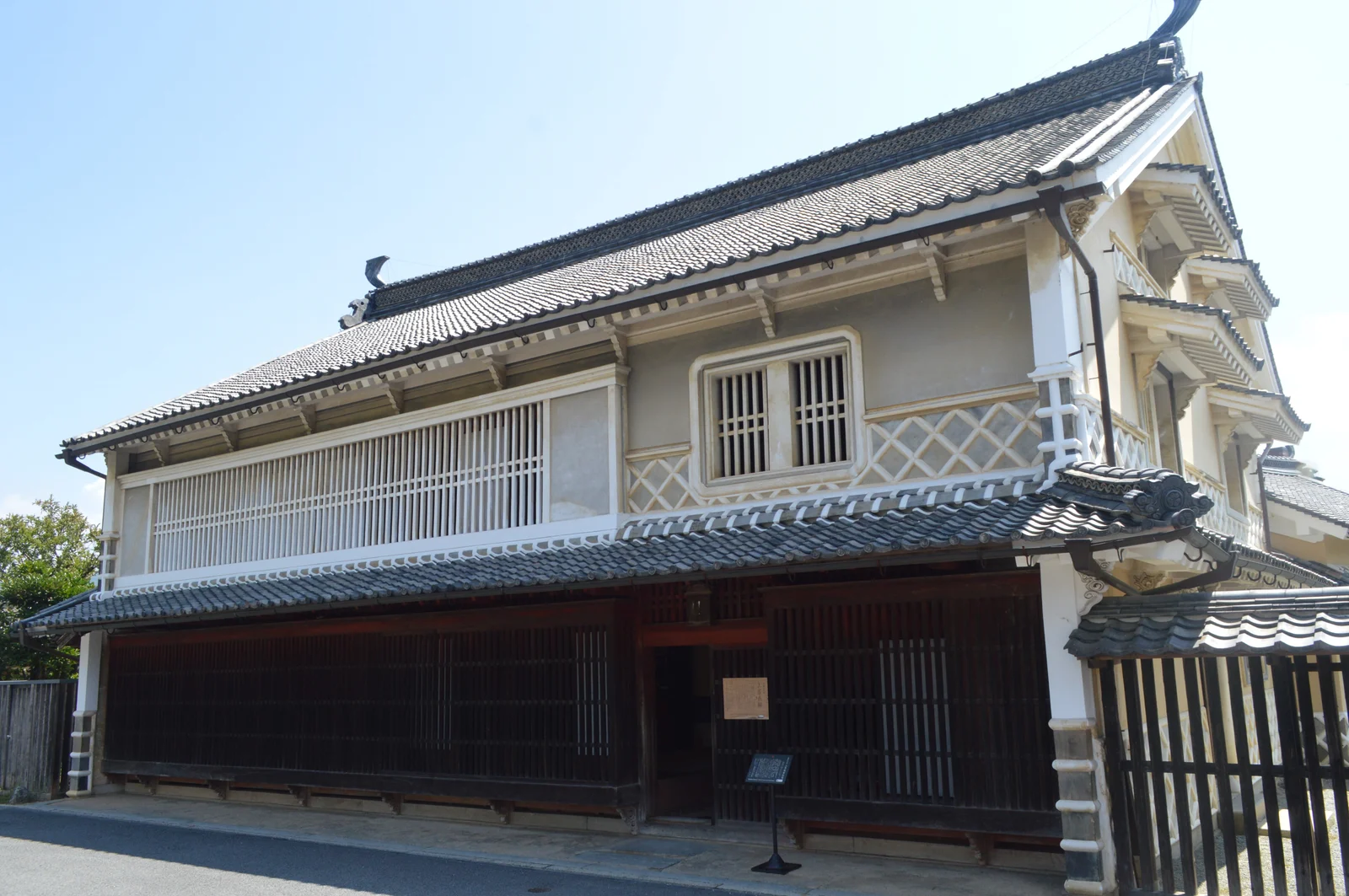 瓦屋根と格子、漆喰壁が見える上芳我邸の正面