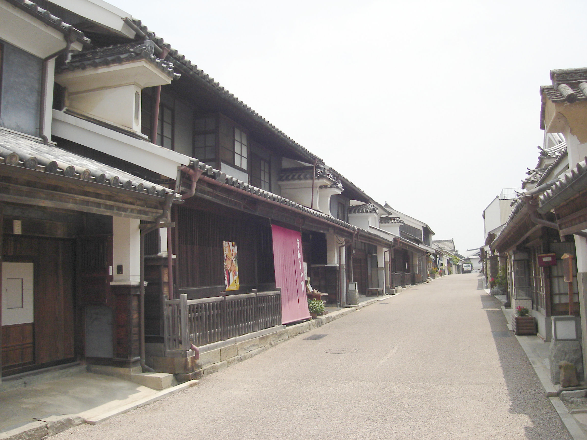 脇町南町の通りに並ぶ町家。隣り合う家の境に、小さな瓦屋根を載せた白いうだつが見える。