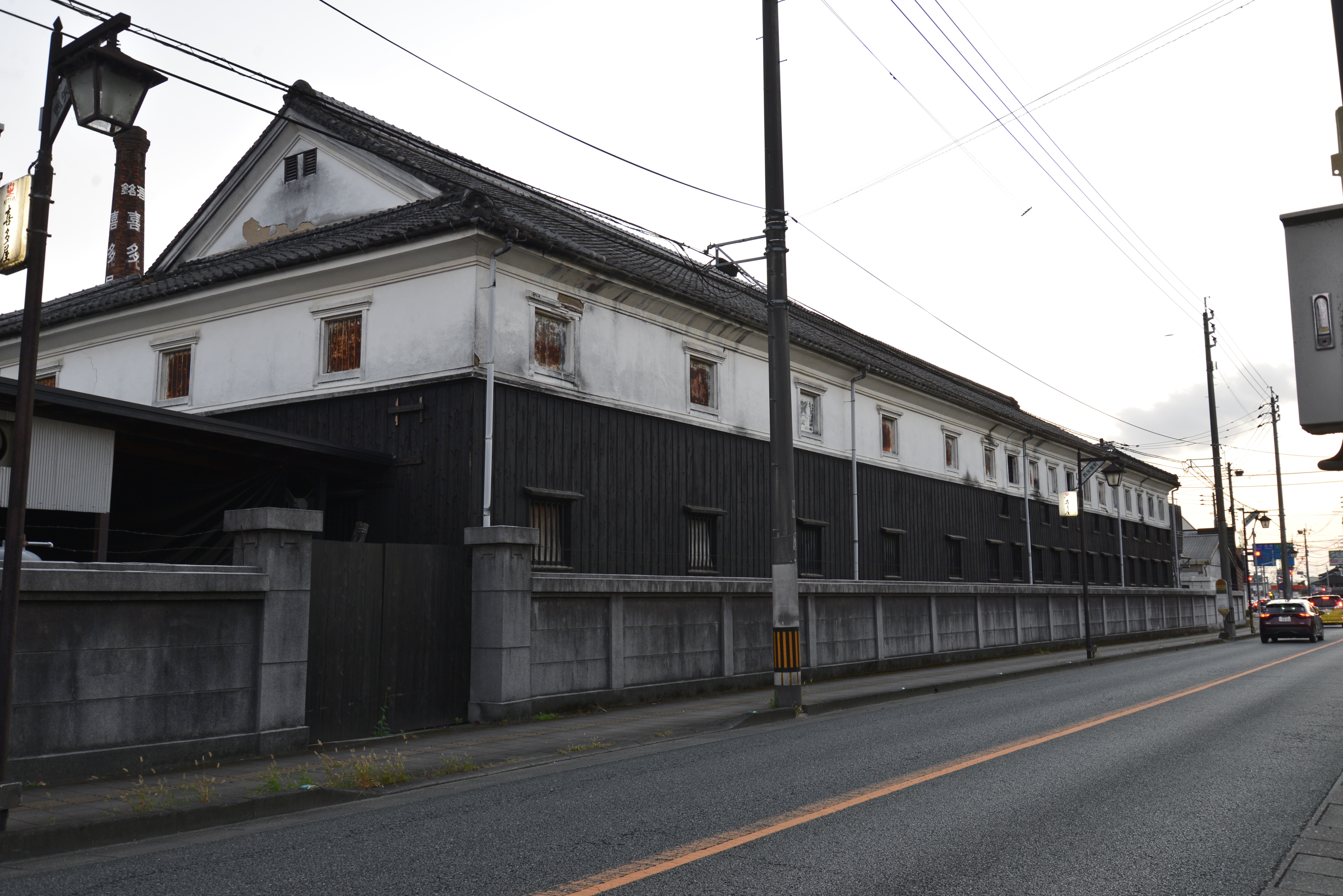 喜多屋の白壁の建物と、社名の入った煙突