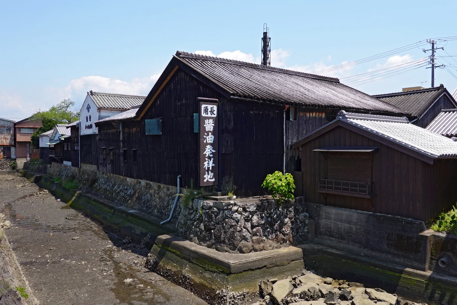 石積みの水辺に接して建つ角長の蔵