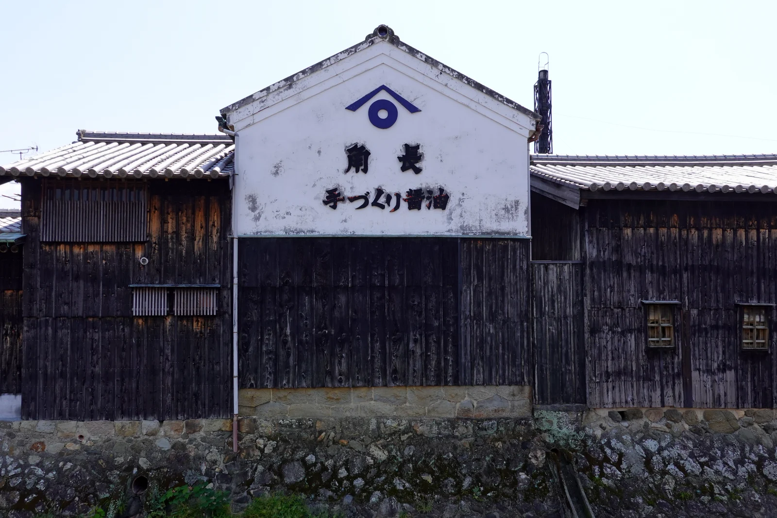 白い壁に角長の名が見える蔵の外観